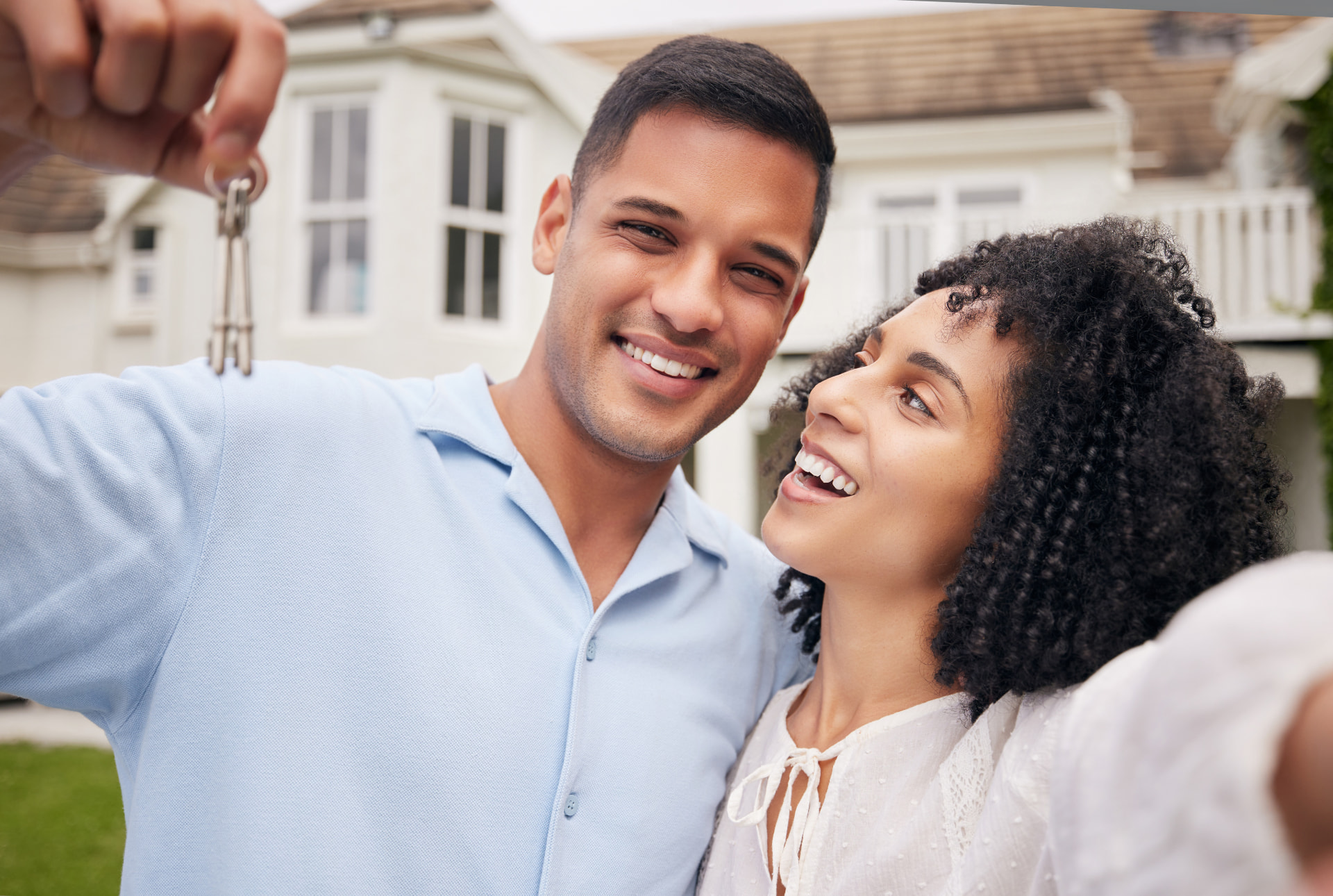 Pareja feliz recibiendo las llaves de su primera casa